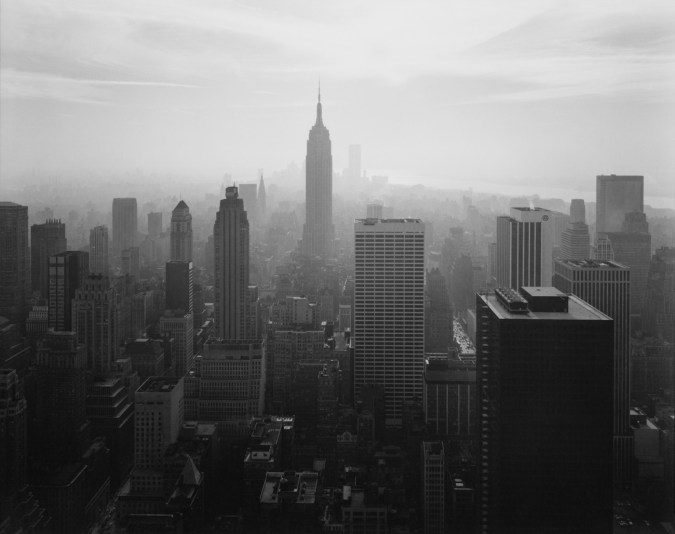 Black-and-white photograph of a city skyline centered on the Empire State Building looking downtown
