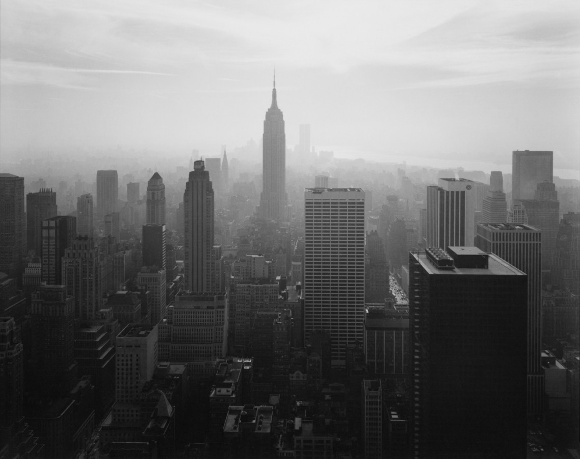 Black-and-white photograph of a city skyline centered on the Empire State Building looking downtown