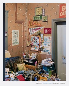 Color image of a poster with a color photograph of a busy and crowded corner of a living room