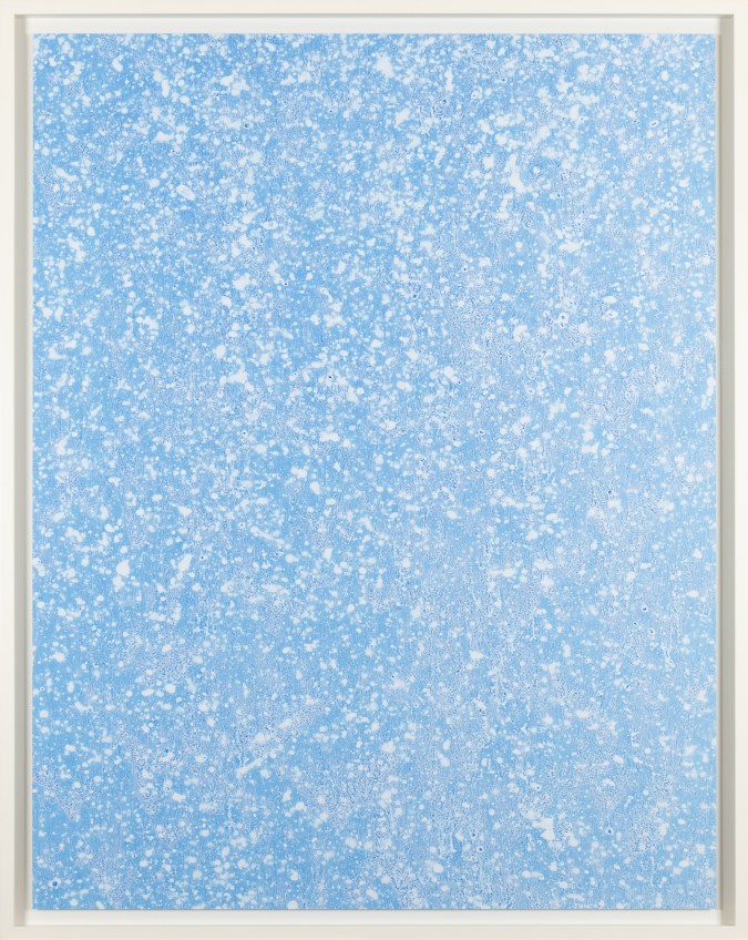 Color image of a color photograph depicting details of water in a light blue hue framed in white