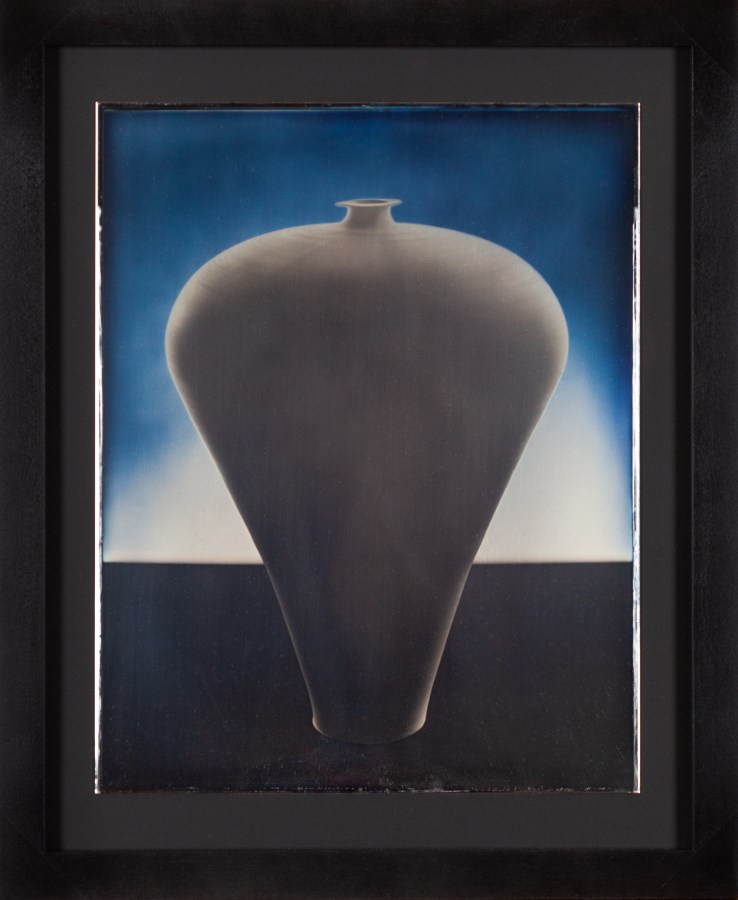 Color image of a daguerreotype depicting a top heavy vase in a blueish hue framed in black