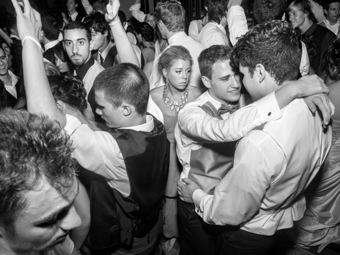 Black and white photograph of teens dancing at prom