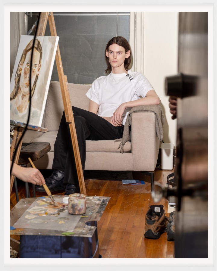 A color photograph of a figure having their portrait painted