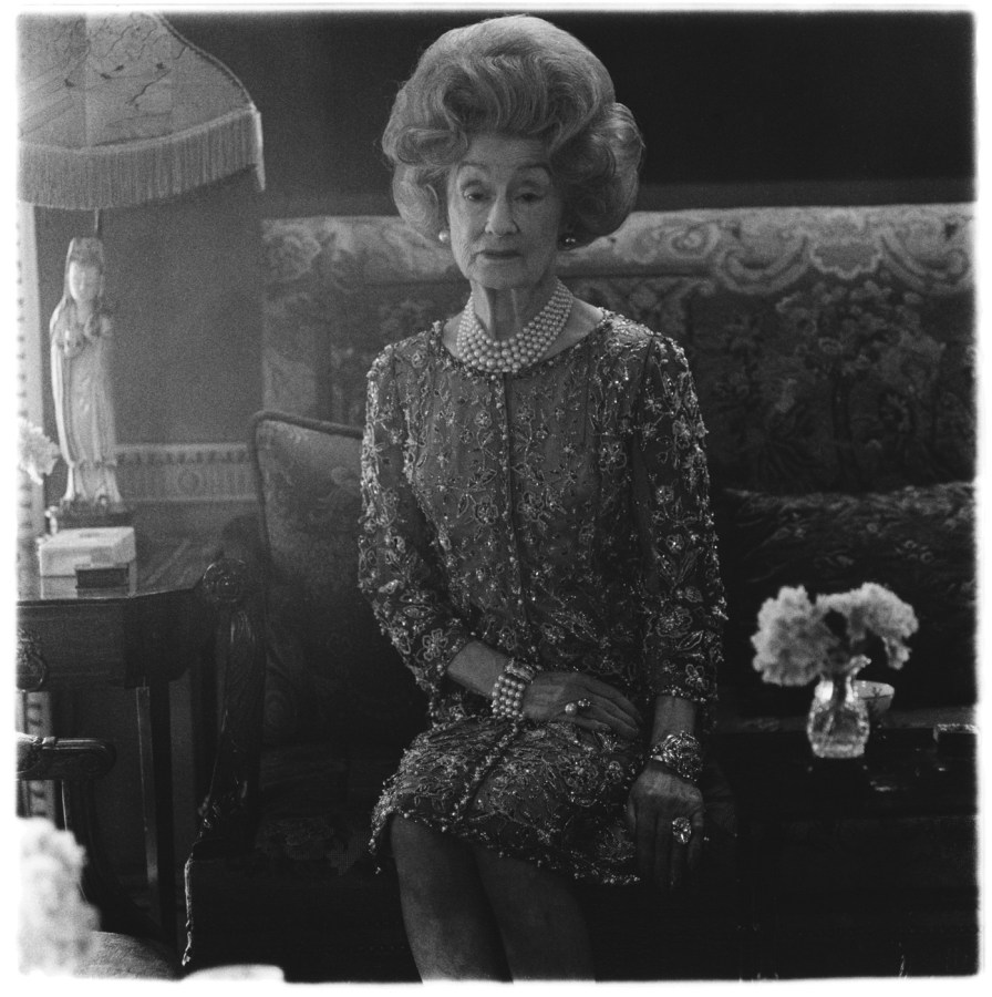 Black-and-white photograph of a woman sitting in an ornate room