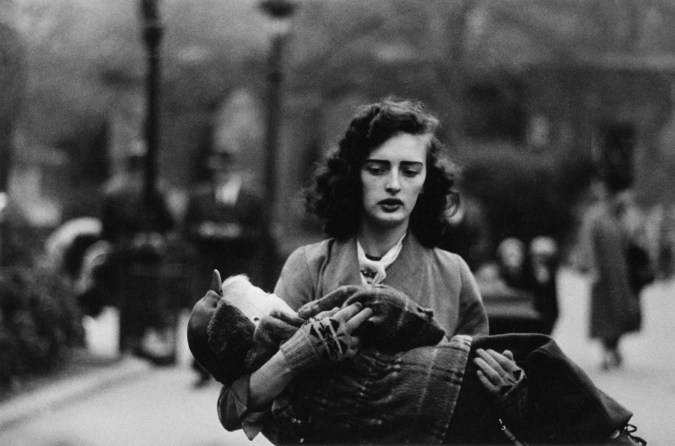 Black-and-white photograph of woman carrying a child