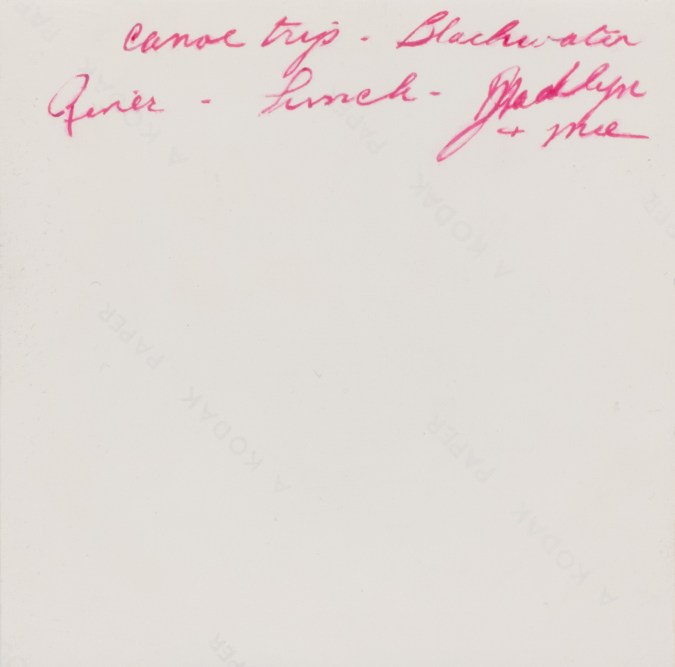 Color image of the backside of a realistically rendered painting depicting red handwriting on back of a photograph