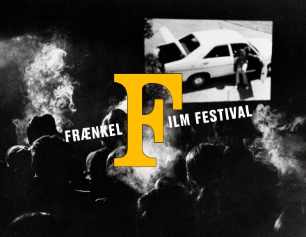 Black and white image of audience members smoking in a theater with a logo overlayed