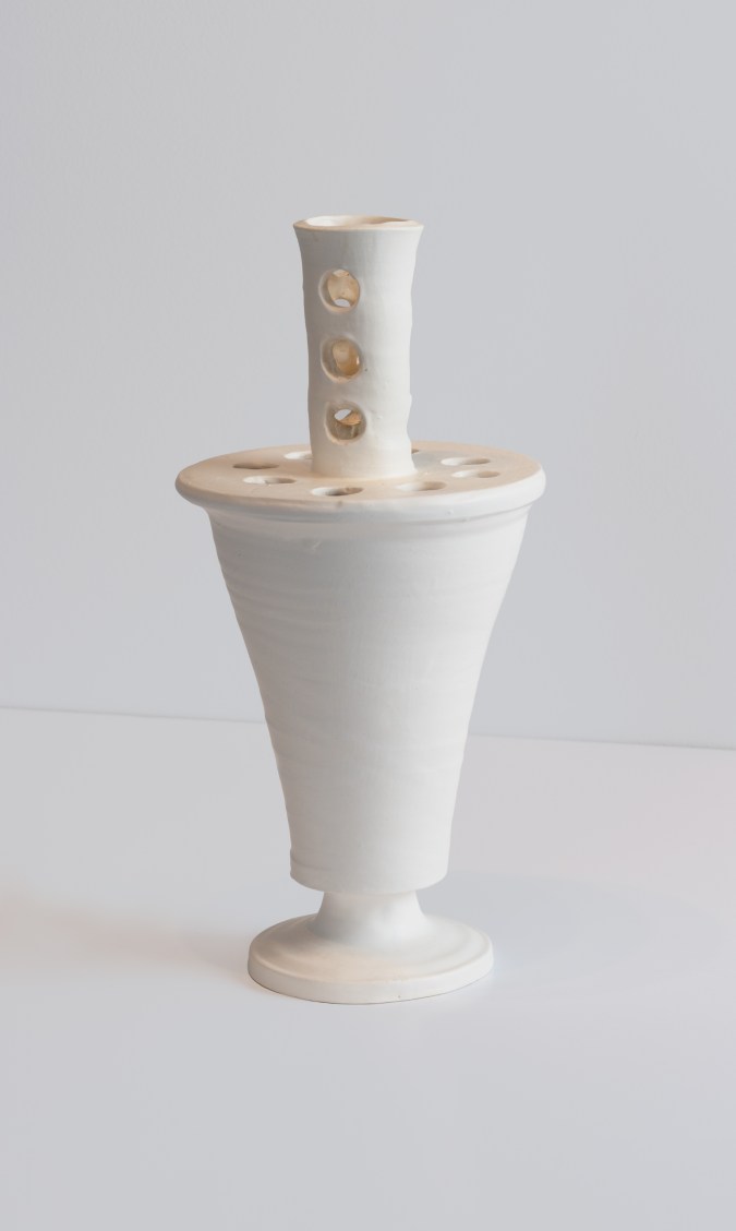 A color photograph of a white vase