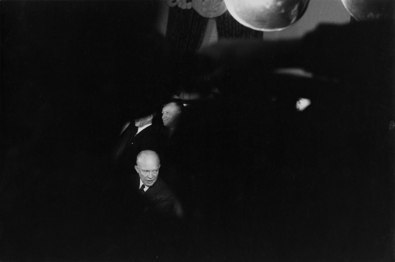 Black-and-white photograph of a man's face isolated amidst a blurred black foreground