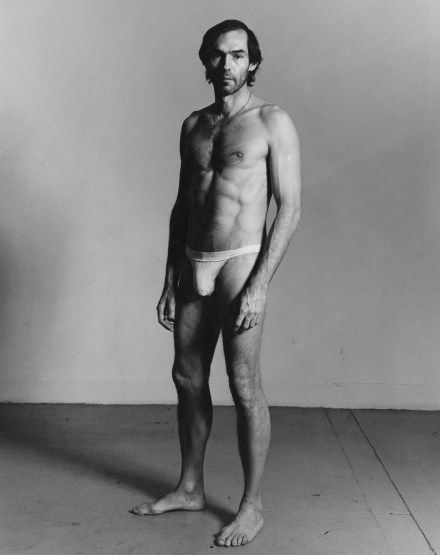 Black and white photograph of man standing in underwear