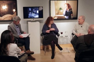 Video still of a group of people seated in a gallery during a panel discussion