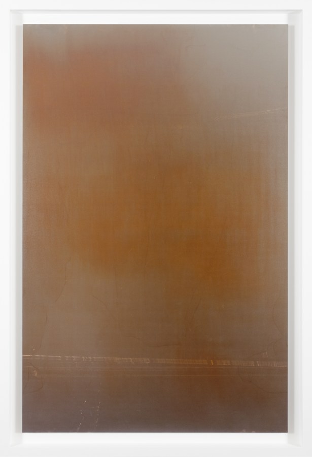 Color image of a photograph with hues and shades of brown, grey, and red framed in white