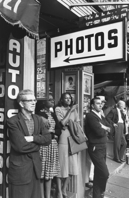 Black and white photograph of several people standing outside of a photography studio