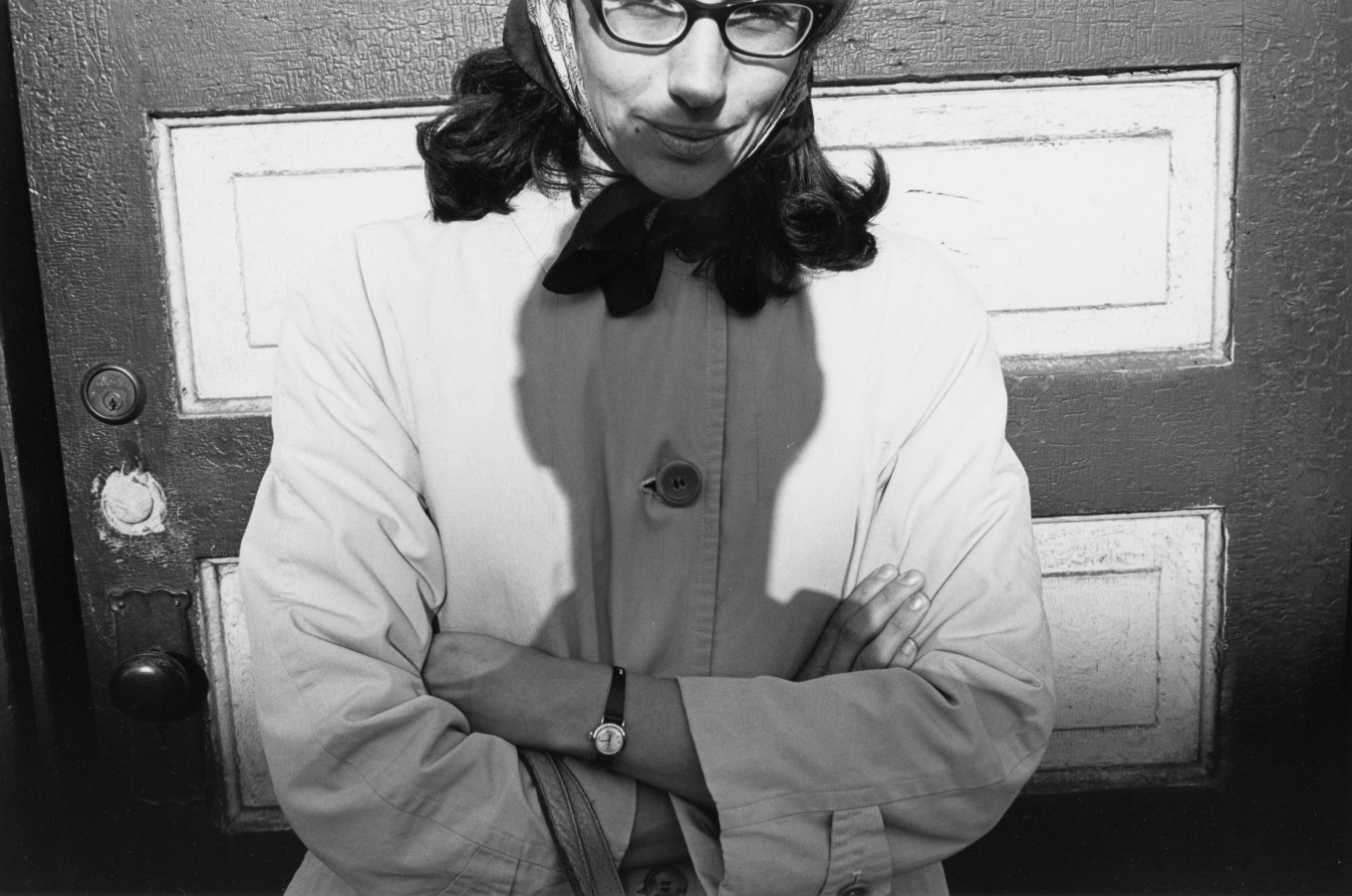 Black-and-white photograph of the shadow of the artist on a woman with her arms crossed