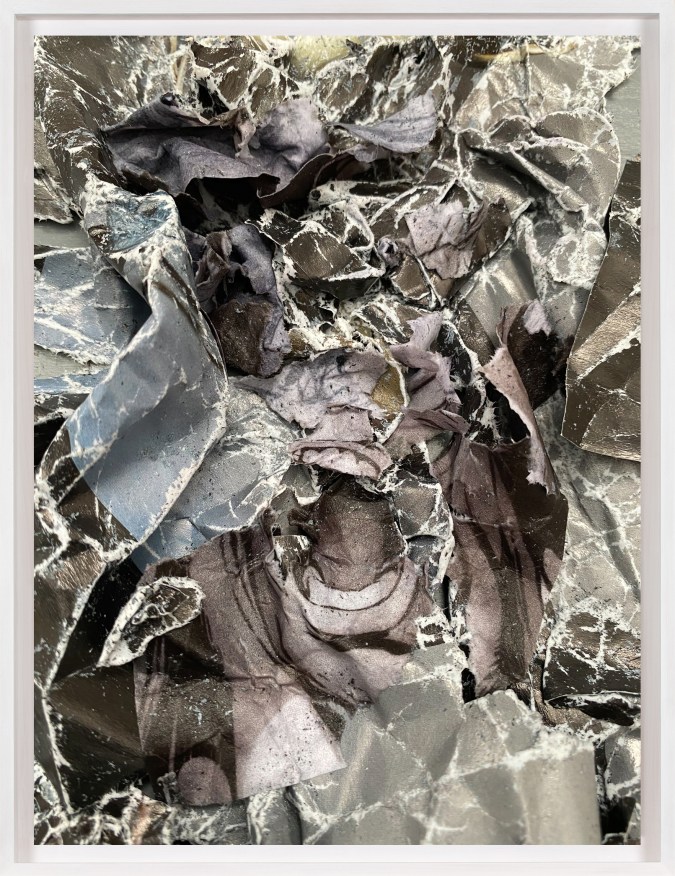 A framed collage of crumpled comic book images, with a screaming mouth at the center