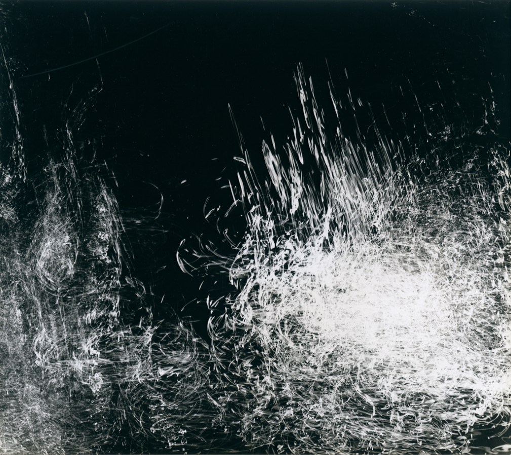 Square black-and-white long-exposure photograph of falling water droplets catching the light