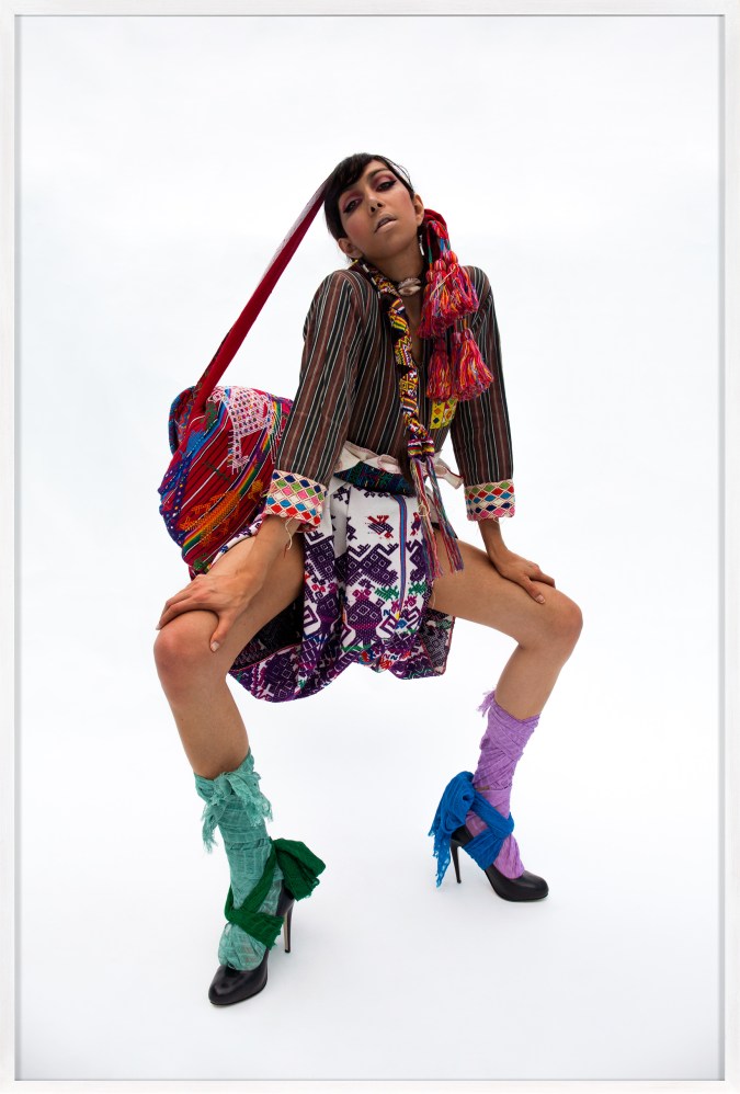 Framed color photograph of a woman in a woven outfit and mismatched socks