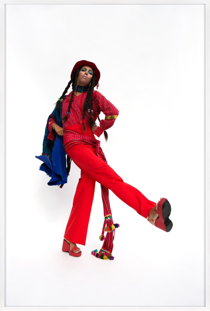 Color photograph of women dressed in cultural garb against white background framed in white