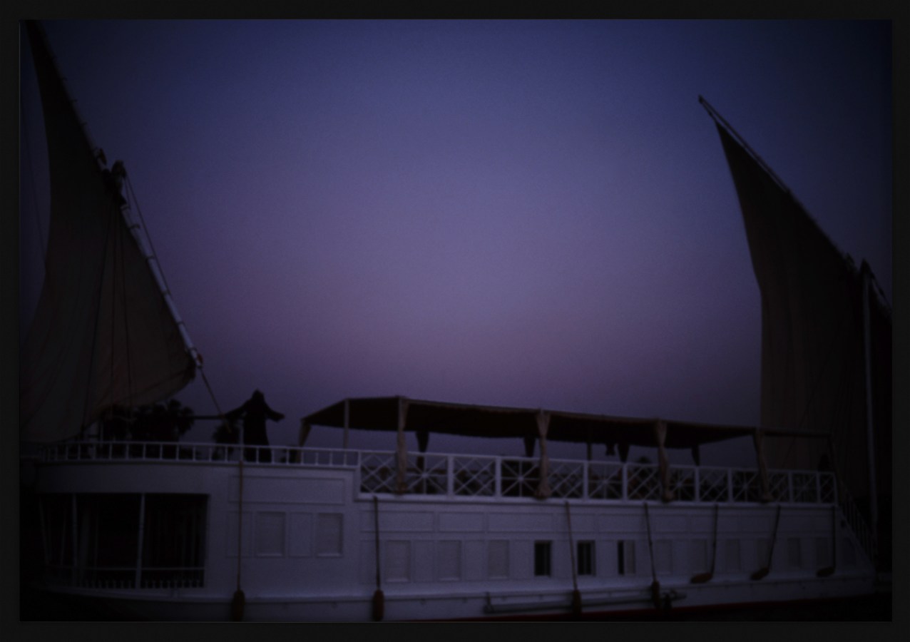 Color photograph of a docked sail boat framed in black