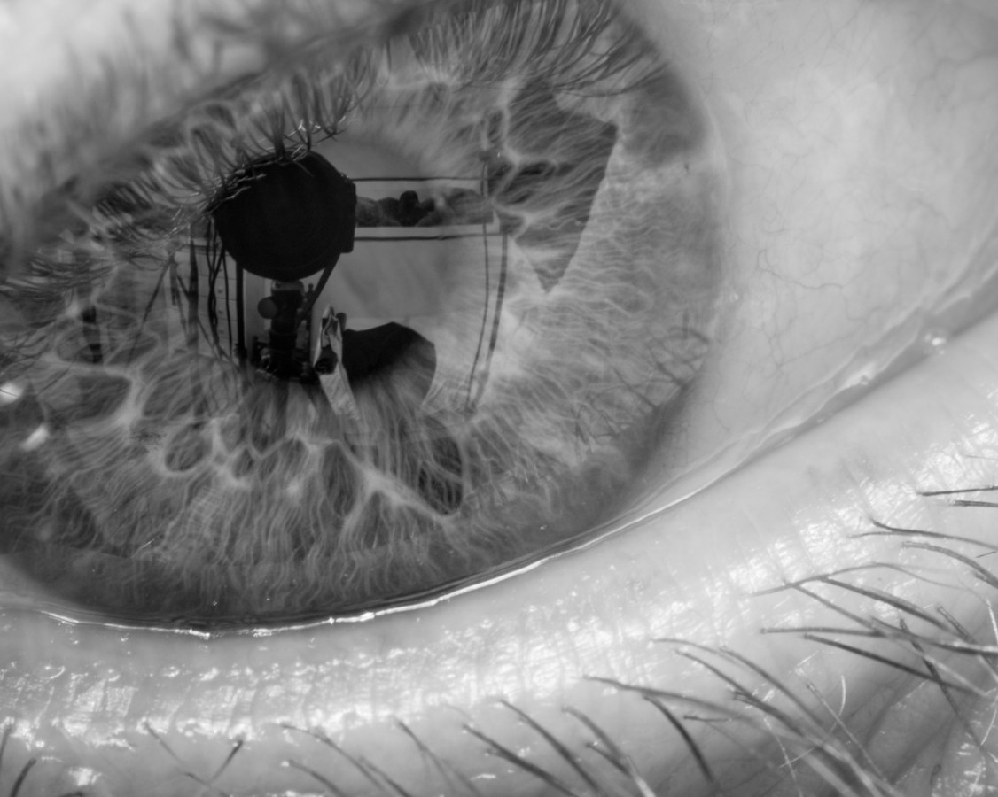 A close up black and white image depicting a reflection in a person's eye