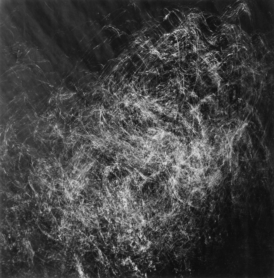 Square black-and-white photograph of light and shadow filtering through rippling water