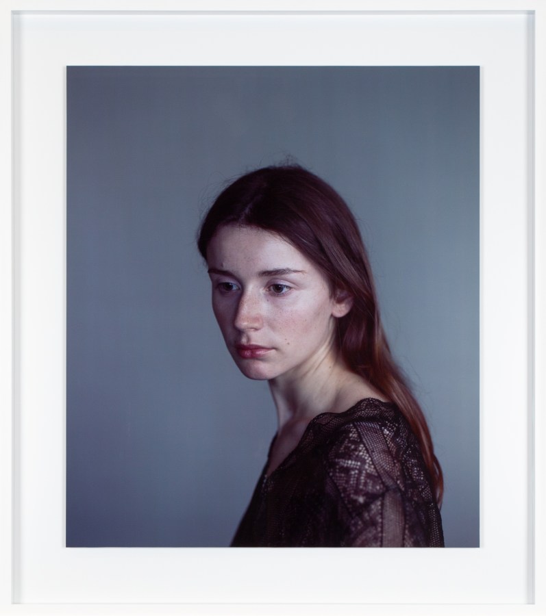 Color photograph of a woman in black lace top framed in white