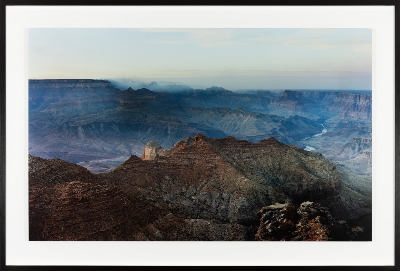 Color photograph of the Grand Canyon at sunset framed in black