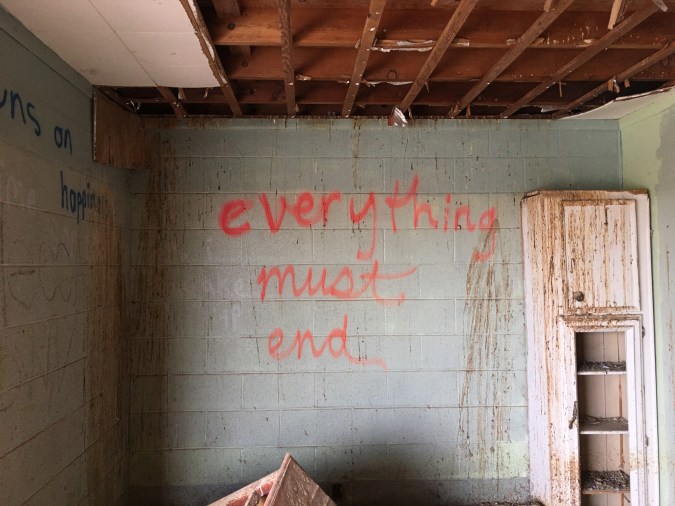 Color photograph of a destroyed interior with grafitti on the walls.