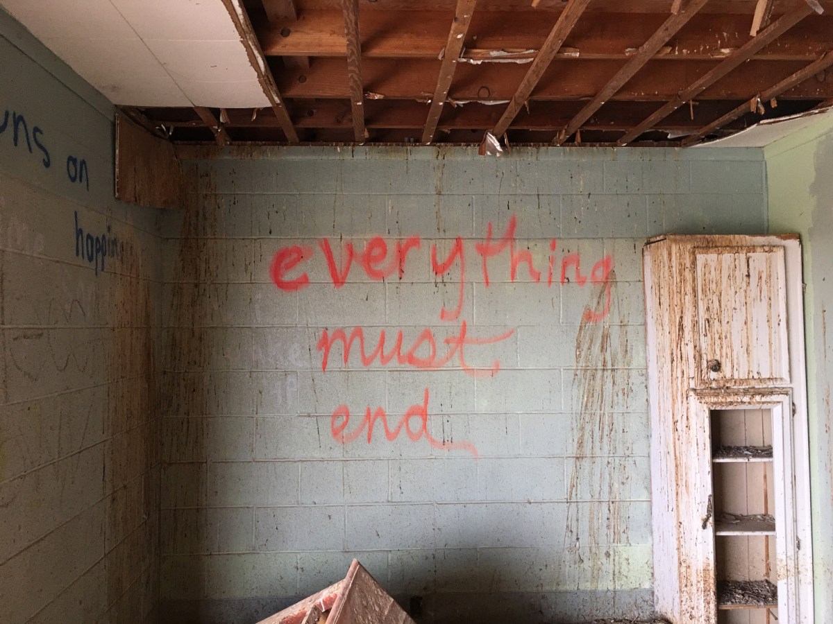 Color photograph of a destroyed interior with grafitti on the walls.