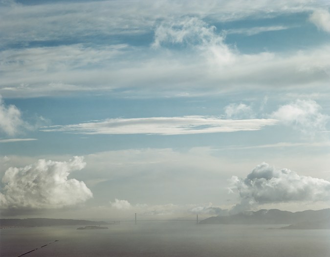 Color image of the Golden Gate Bridge on the horizon including the bay and sky.