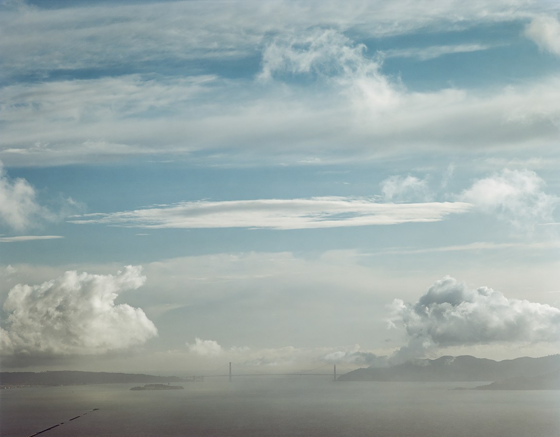 Color image of the Golden Gate Bridge on the horizon including the bay and sky.