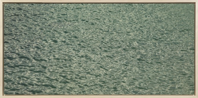 Color photograph of small waves and ripples on the surface of green water