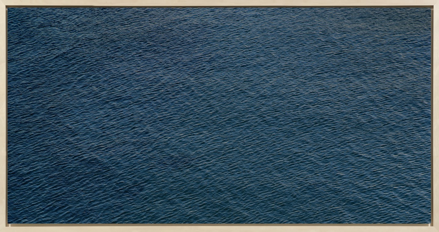 Color photograph of the rippled surface of a dark blue sea