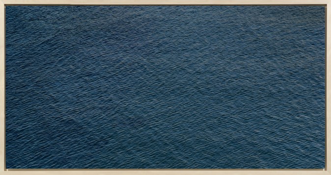 Color photograph of the rippled surface of a dark blue sea