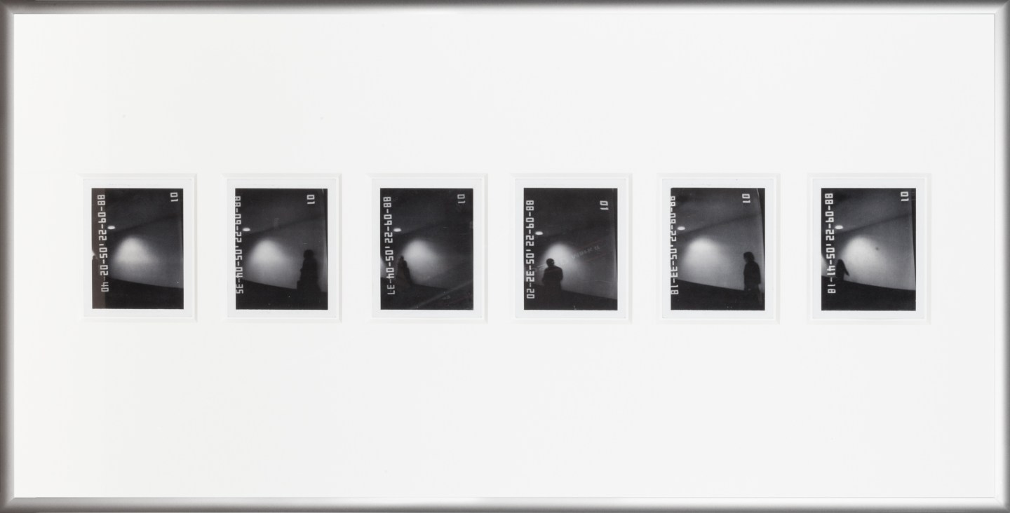 Color image of six black and white polaroids with time stamps depicting shadowy figures in silver frame