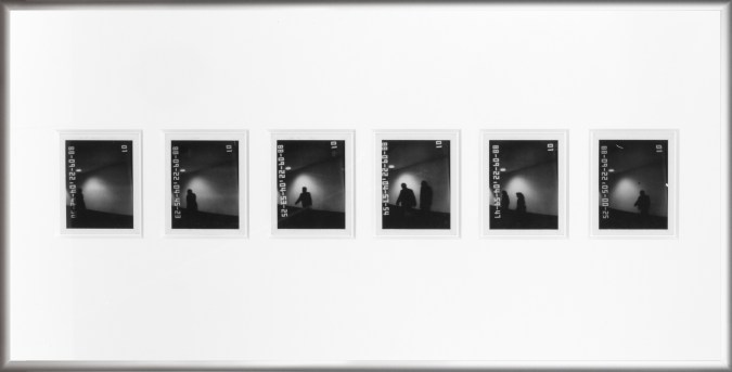 Color image of six black and white polaroids with time stamps depicting shadowy figures in silver frame