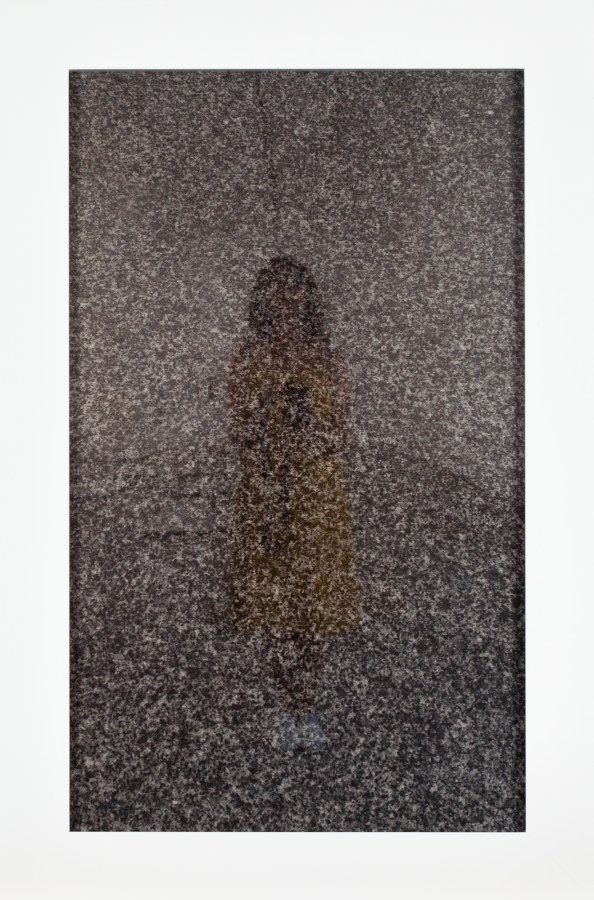 A framed photograph of the photographer's reflection in the surface of a headstone