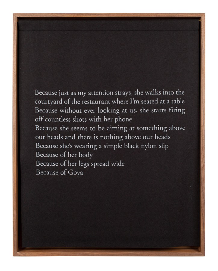 A wooden box with a black curtain, embroidered with white text, describing a photograph of a woman