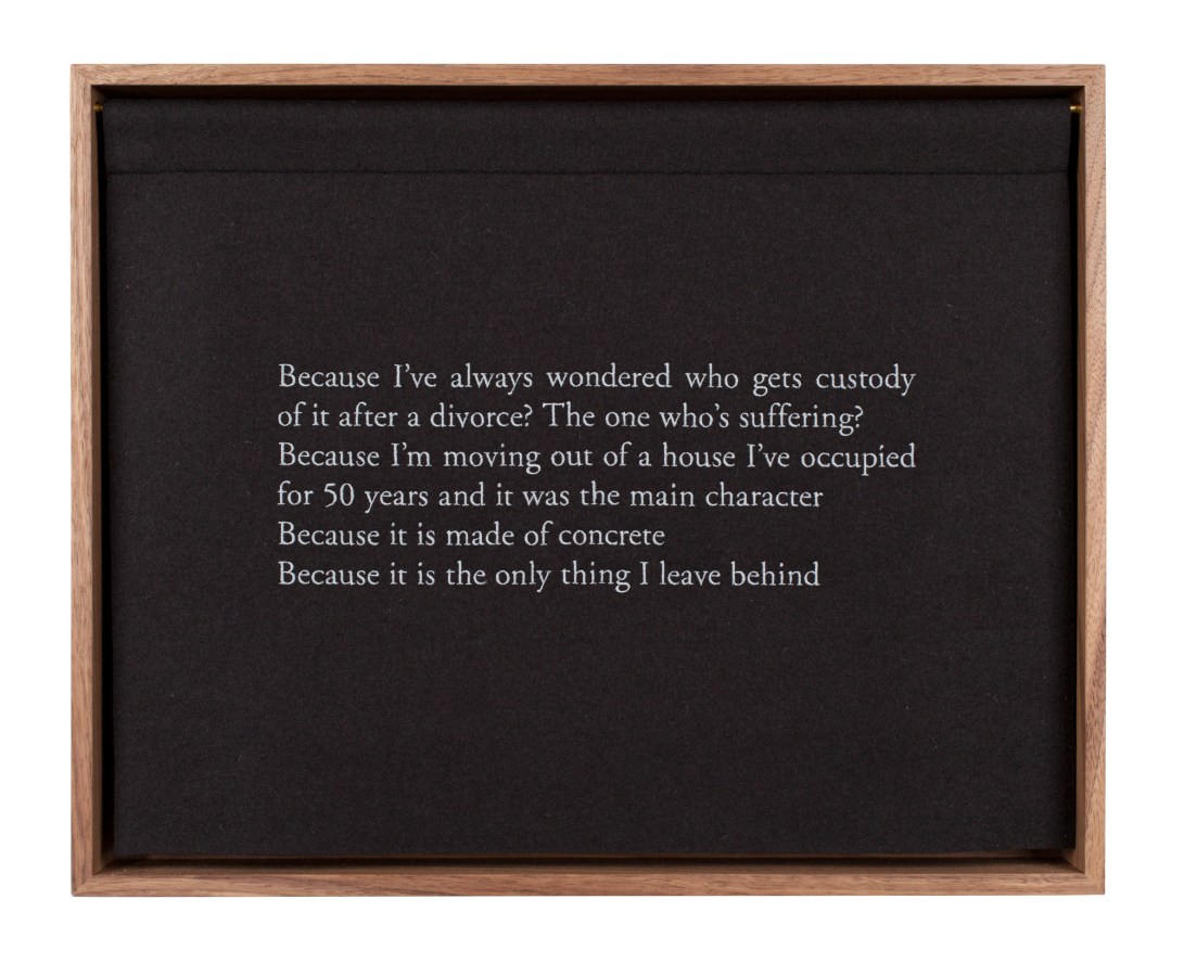 A wooden box, with a black curtain, embroidered with white text, describing a bed