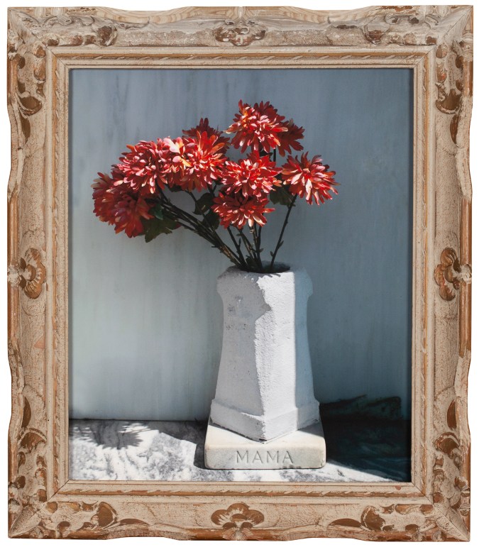 Color photograph of bouquet in concrete vase with Mama inscription framed in wooden frame