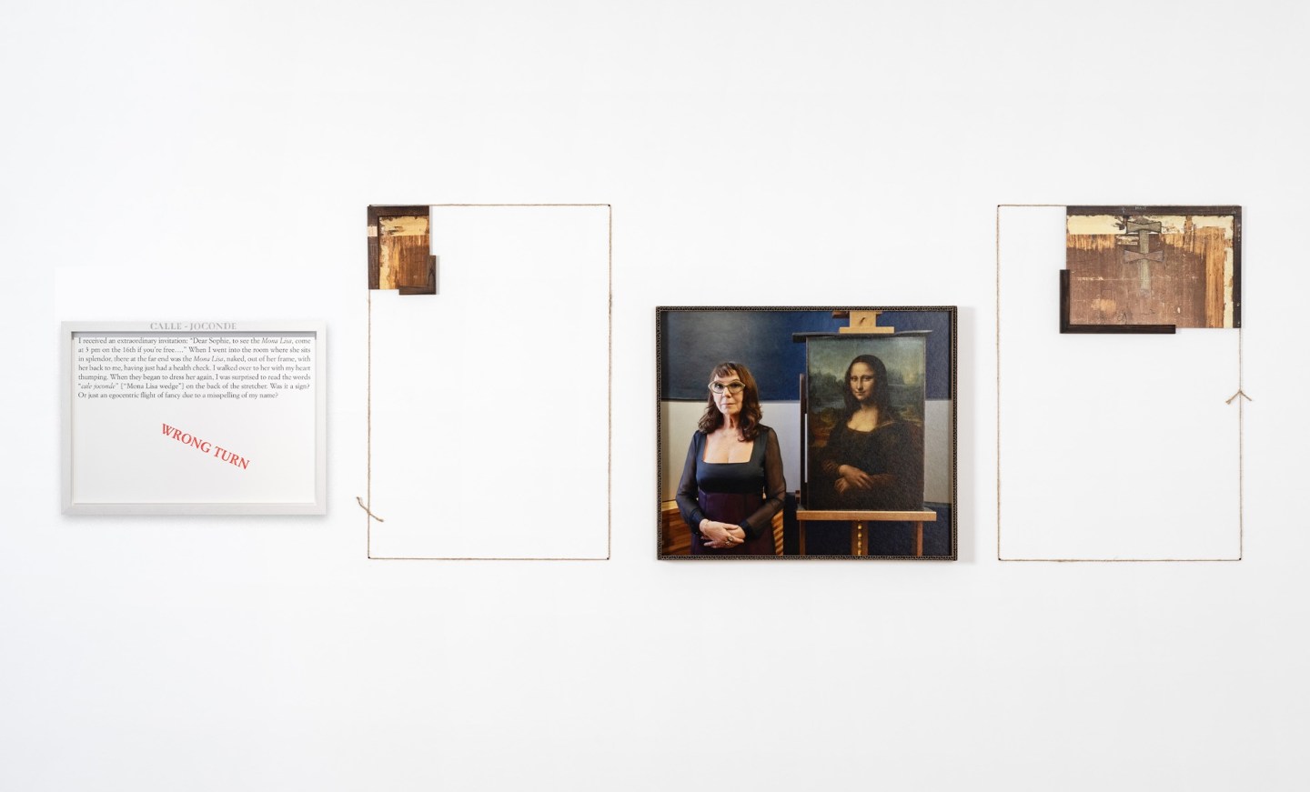 Color image of an artwork including a text panel, a color photograph depicting a woman in a black dress and glasses standing next to the Mona Lisa, Leonardo da Vinci’s famous painting of a woman between two vertical rectangles made of twine