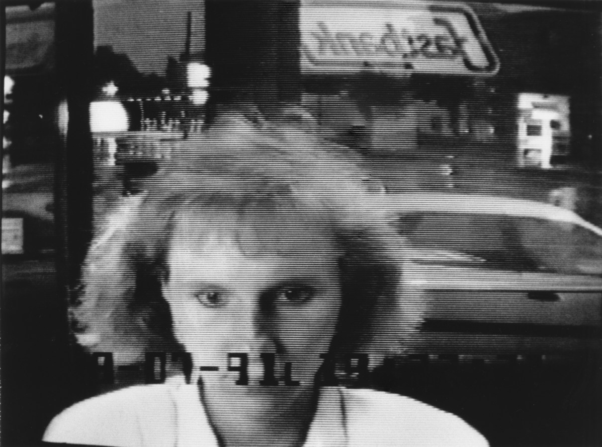 Black and white photograph of a woman at an ATM