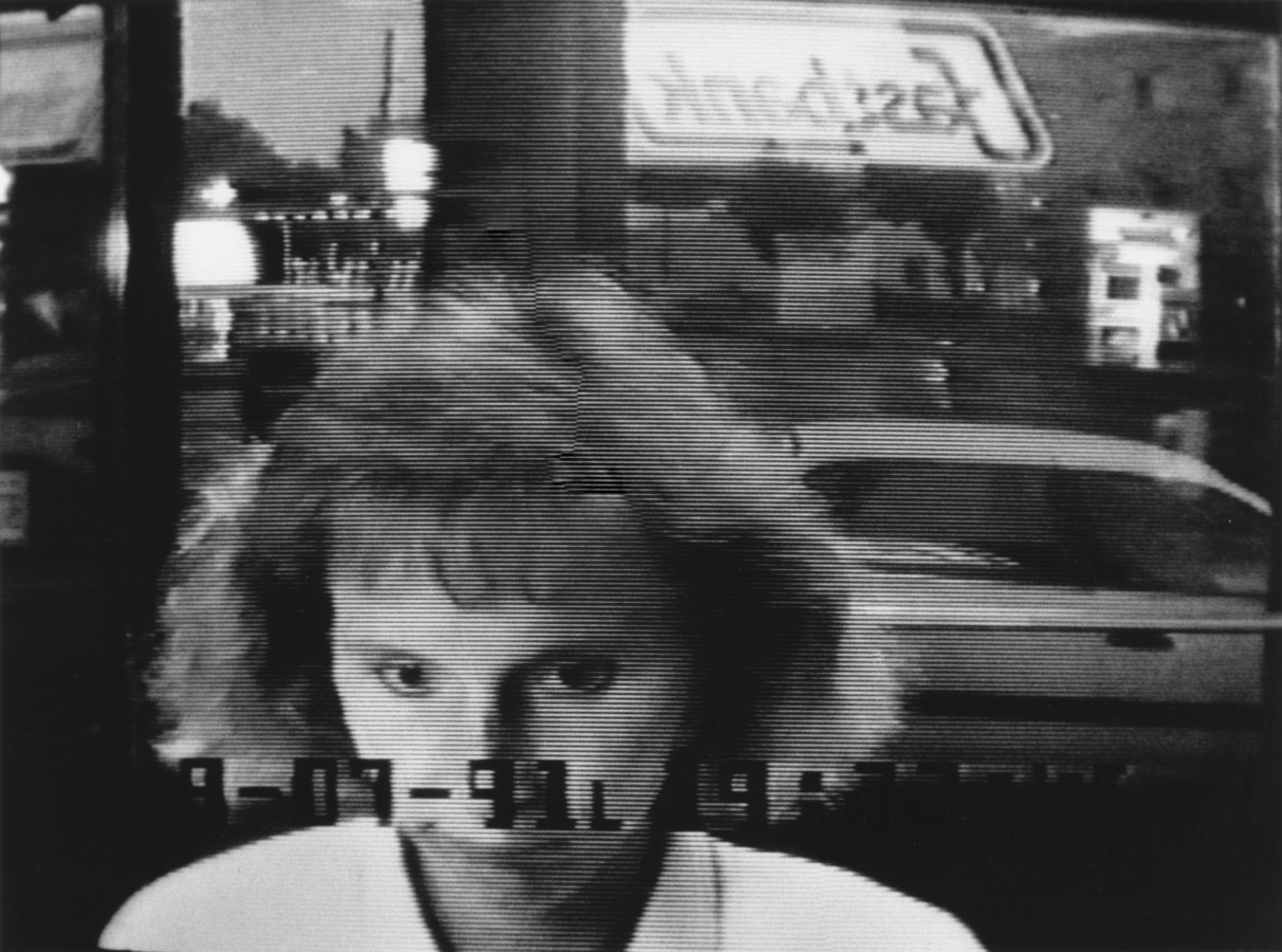Black and white photograph of a woman at an ATM