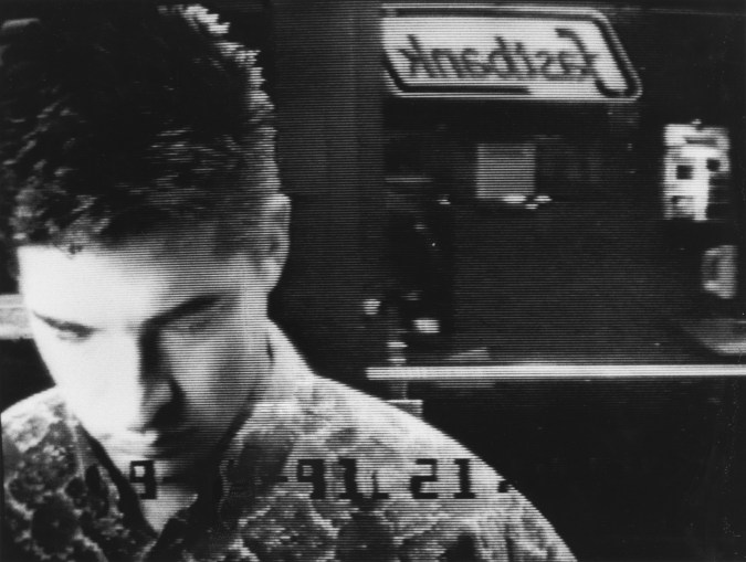 Black and white photograph of a man at an ATM