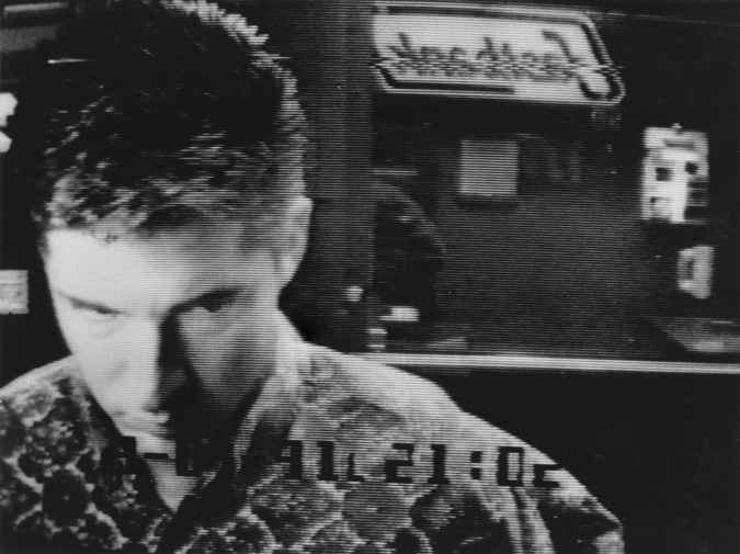 Black and white photograph of a man at an ATM