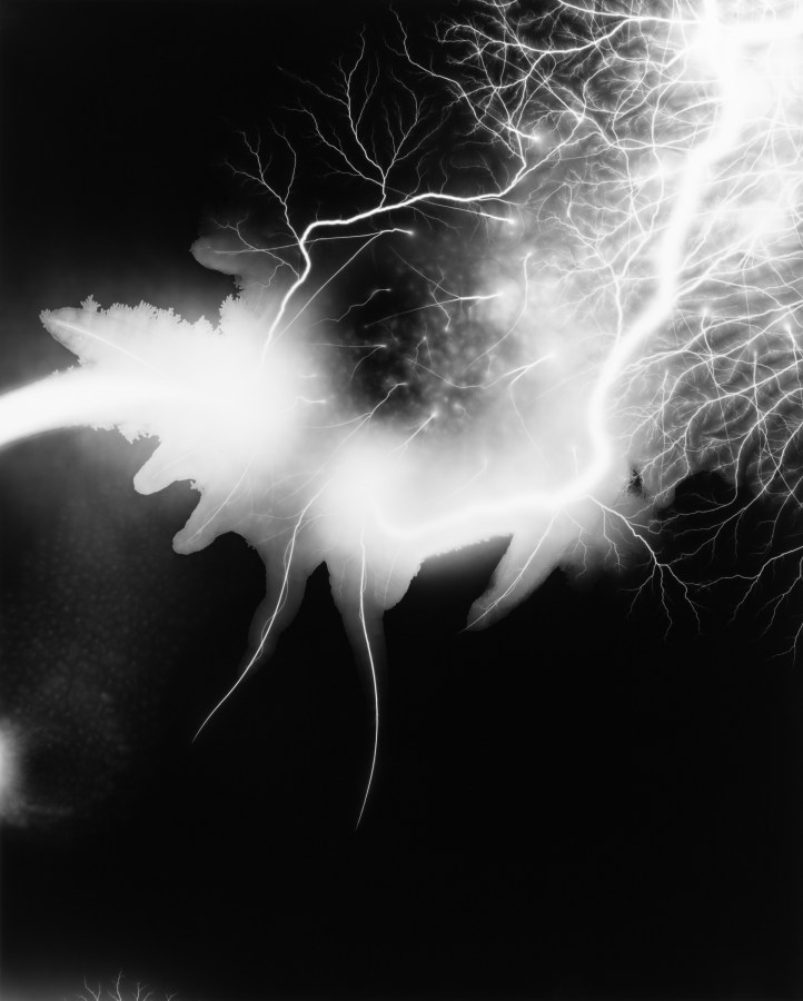 Black and white photograph of lighting striking against black background
