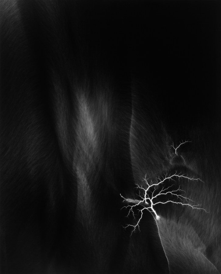 Black and white photograph of lighting striking against black background