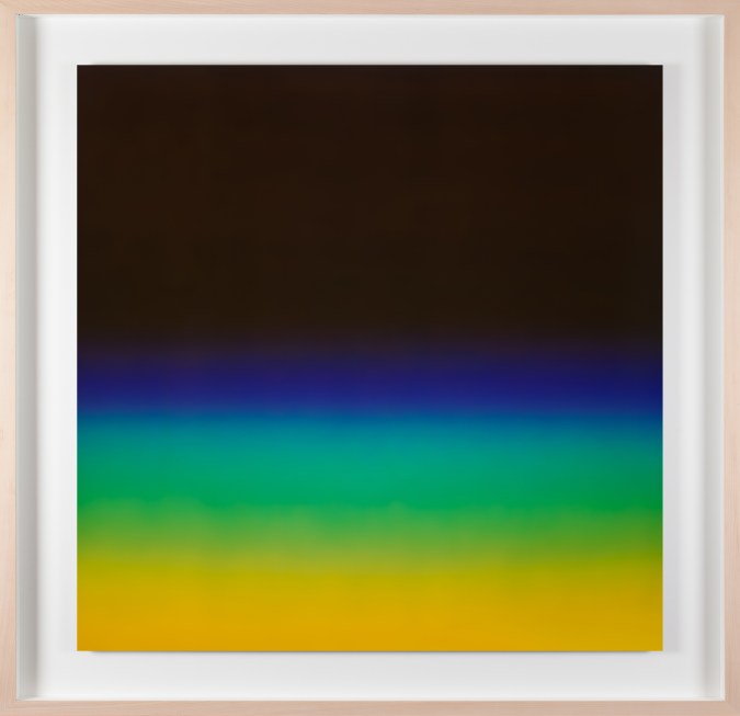 A framed photograph of a black color field with blue, green and yellow gradients on the bottom