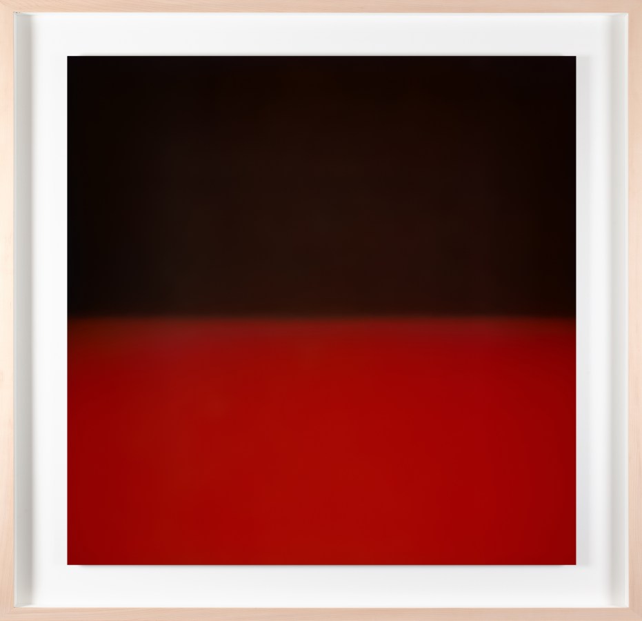 Framed color photograph of a gradient of black and red light.