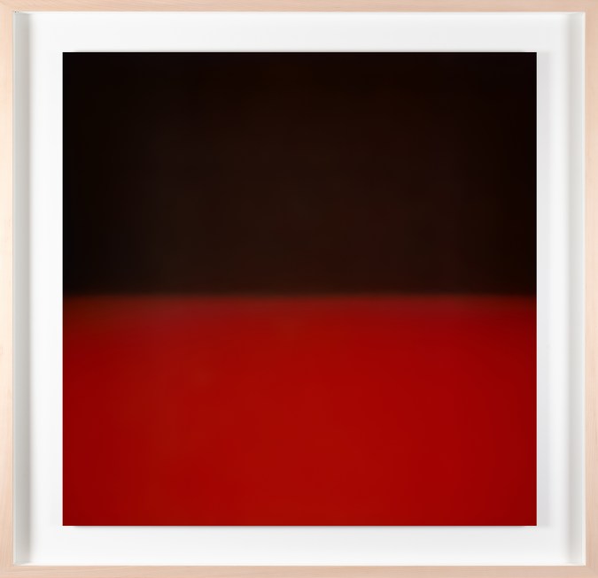 Framed color photograph of a gradient of black and red light.